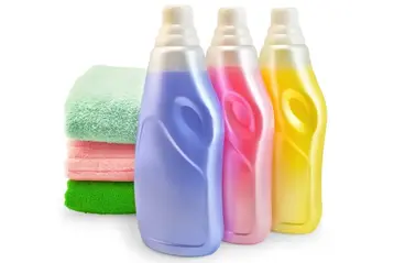 Fabric softener bottle beside a stack of clean towels