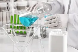 Clinical worker in gown and gloves trained in chemical safety